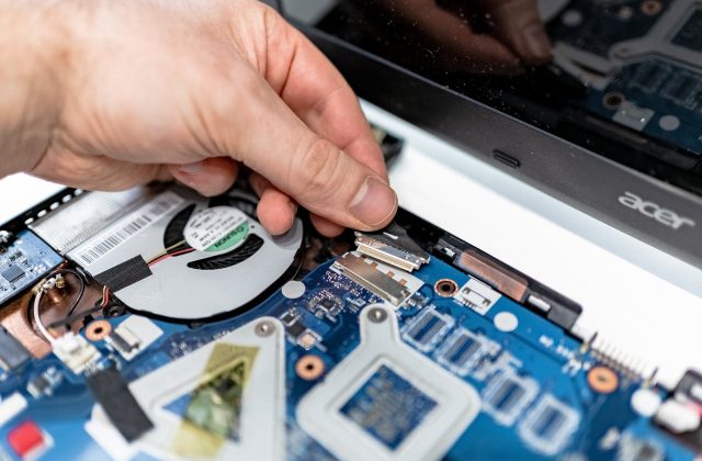 man fixing the motherboard on the laptop
