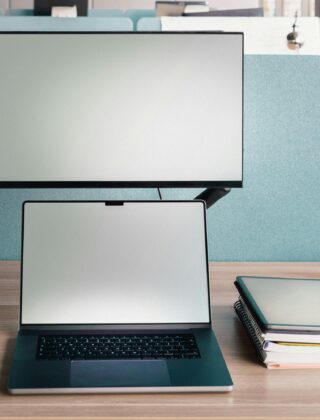 Laptop with second monitor stacked above on adjustable arm in coworking space - second screen setup for remote work productivity